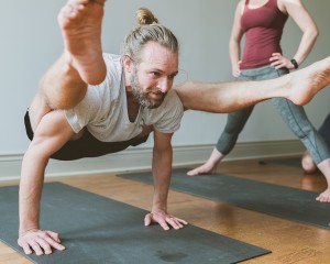 man working hard during ashtanga yoga practice in mysore class at yoga studio